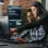 A woman pointing out something on her colleague's monitor screen in a modern office setting